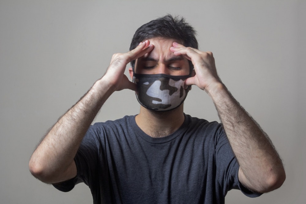 A sick man wearing mask having swear headache. usman yousaf, unsplash