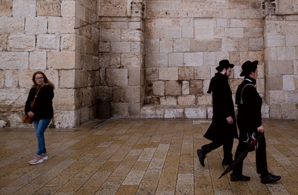 Haredim walk toward the Jaffa Gate into the Old City of Jerusalem, past a set of ancient Ottoman inscriptions. by Levi Clancy, UNSPLASH