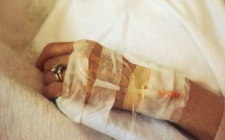 A closeup of a chemotherapy IV in a patient's hand.