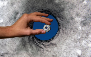 A perforated stone from NEG II in front of its 3D mode
