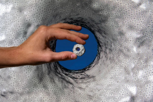 A perforated stone from NEG II in front of its 3D mode
